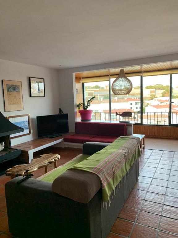 een woonkamer met een bank, een tafel en een tv bij Can Ramon in Cadaqués