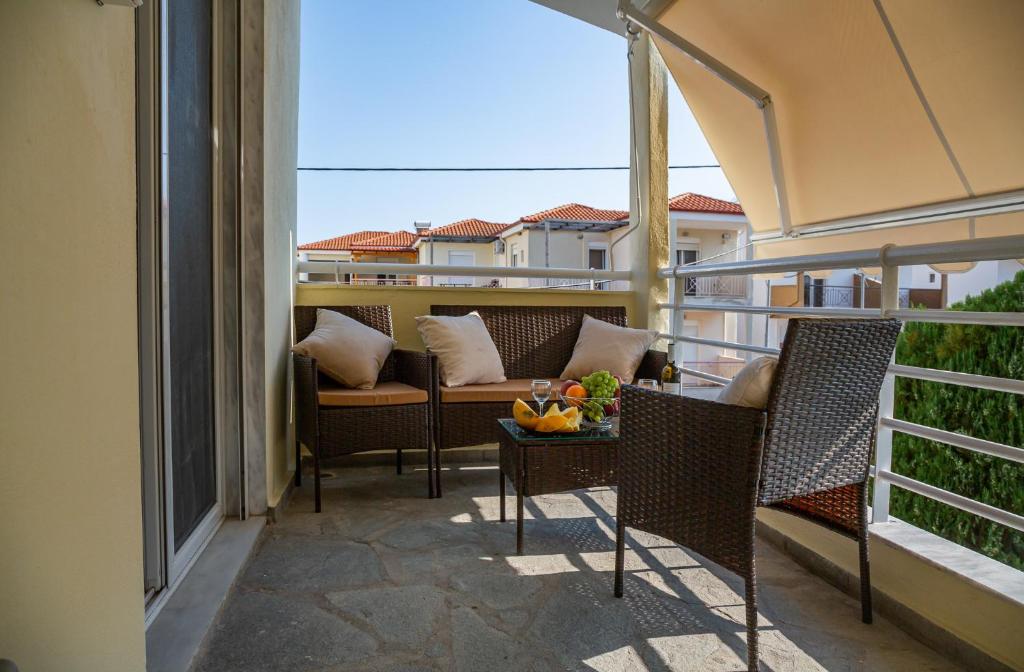 a balcony with chairs and a couch and a table at Apartment in Skala Fourkas in Skála Foúrkas