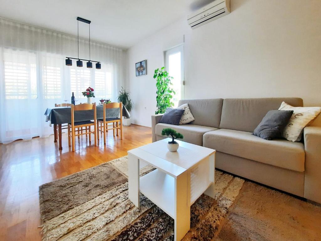 uma sala de estar com um sofá e uma mesa em Apartment Violetta-Punta em Umag