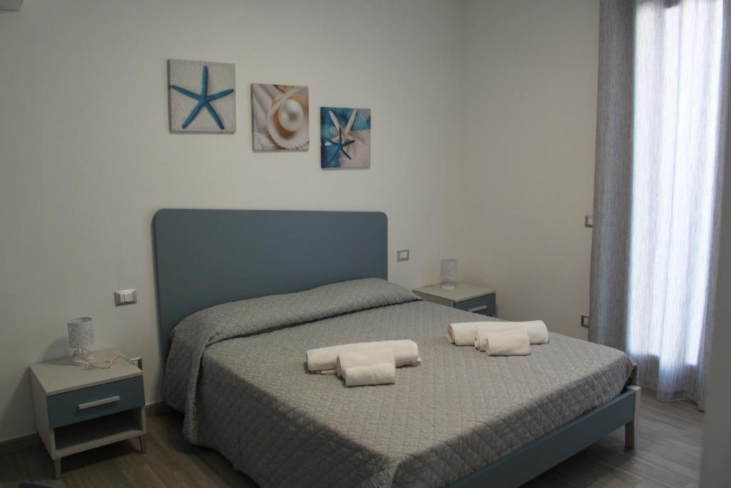 a bedroom with a bed with two towels on it at Akoya Apartments in San Vito lo Capo
