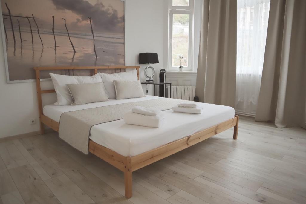 um quarto com uma cama grande e almofadas brancas em Three Rings Apartments em Karlovy Vary