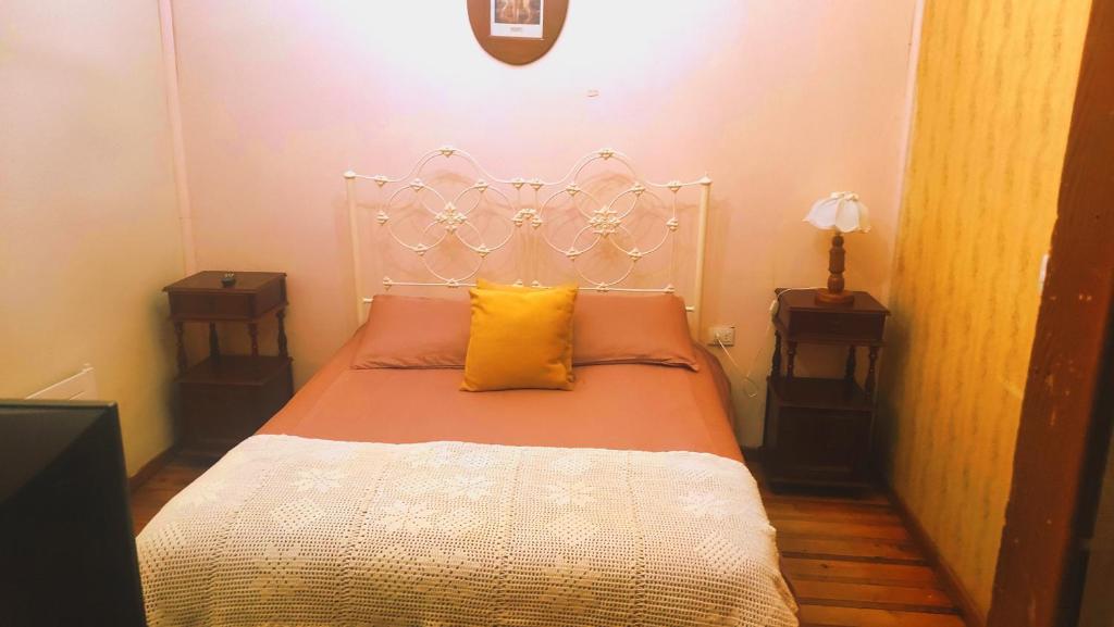 um quarto com uma cama branca e almofadas amarelas em HOTEL Halley em Vicuña