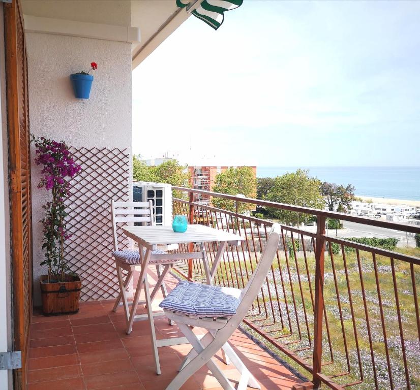 d'un balcon avec une table et des chaises donnant sur l'océan. dans l'établissement ÁTICO FRENTE AL MAR, à Canet de Mar