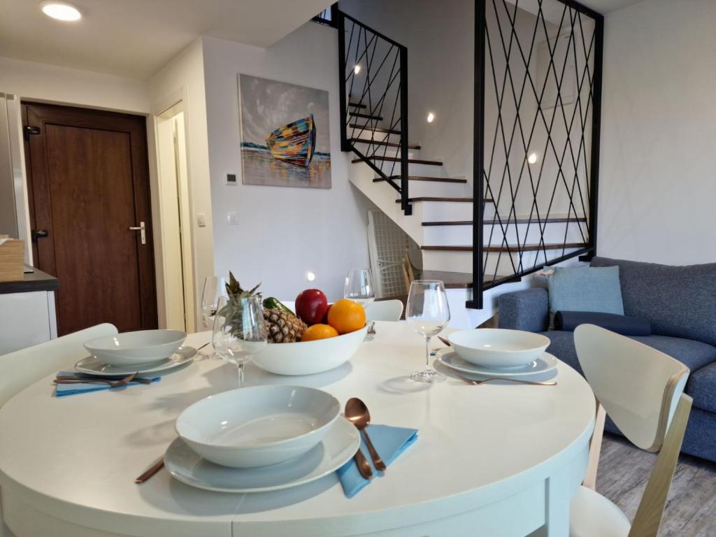 a white table with bowls of fruit on it in a living room at Anna24 Holidays in Vantačići