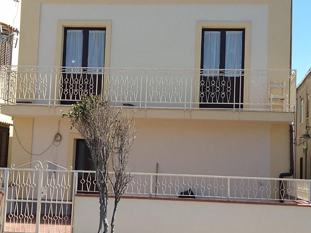 ein Gebäude mit Balkonen und einem Baum davor in der Unterkunft Casa Cecilia in Gallico Marina