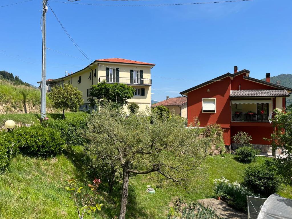 a house on a hill with a tree in the foreground at Nonna Arde in Beverino