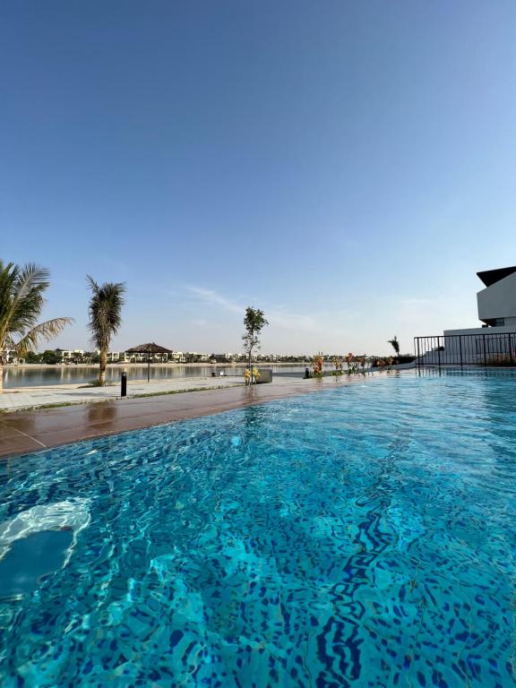 una gran piscina azul junto a una playa en Relaxing villa with access to pool and beach en Ras al-Jaima