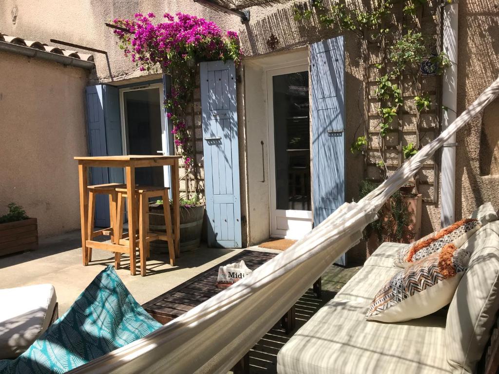 a porch with a couch and a chair on a balcony at Appartement climatisé avec terrasse in Carcassonne