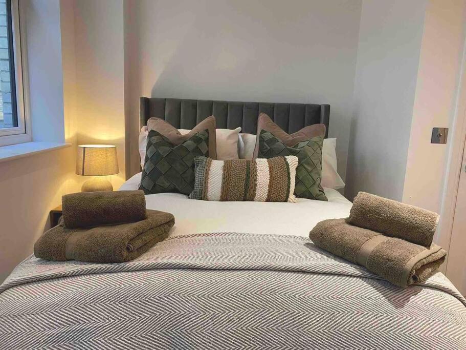 a bedroom with a large bed with pillows on it at Brand New Property - Bradford City Centre in Bradford