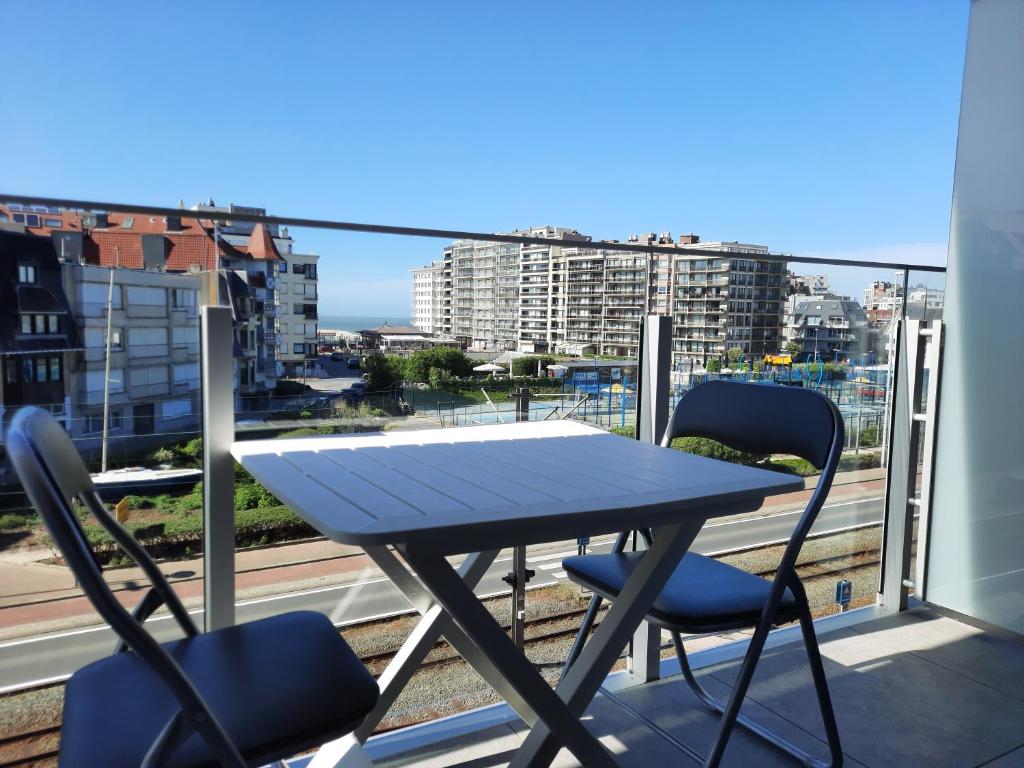 een tafel en stoelen op een balkon met uitzicht bij Beachstudio Westende with sea view in Middelkerke