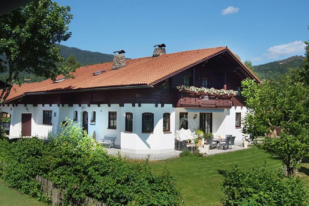 ein großes weißes Haus mit rotem Dach in der Unterkunft Ferienwohnung Fritz in Bodenmais