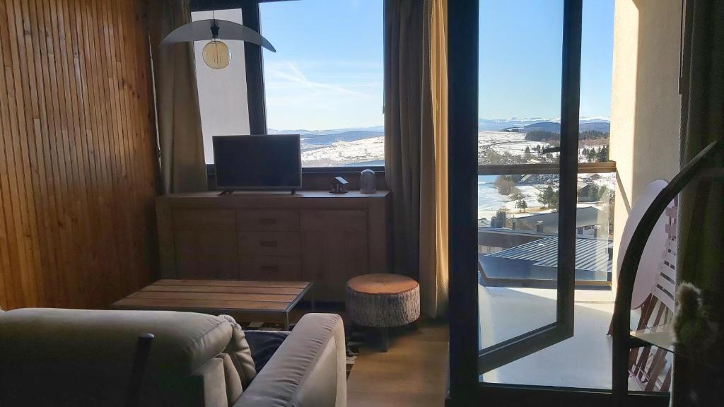Televízia a/alebo spoločenská miestnosť v ubytovaní Un petit coin de paradis à Super Besse