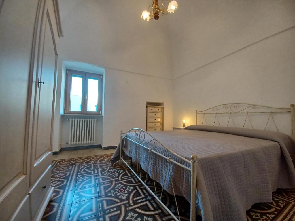 een slaapkamer met een bed en een raam bij Casa Fortuna in Cisternino