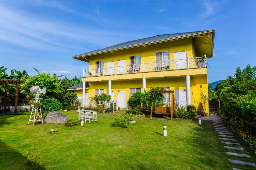 a yellow house with a yard in front of it at Dream House in Pinghe