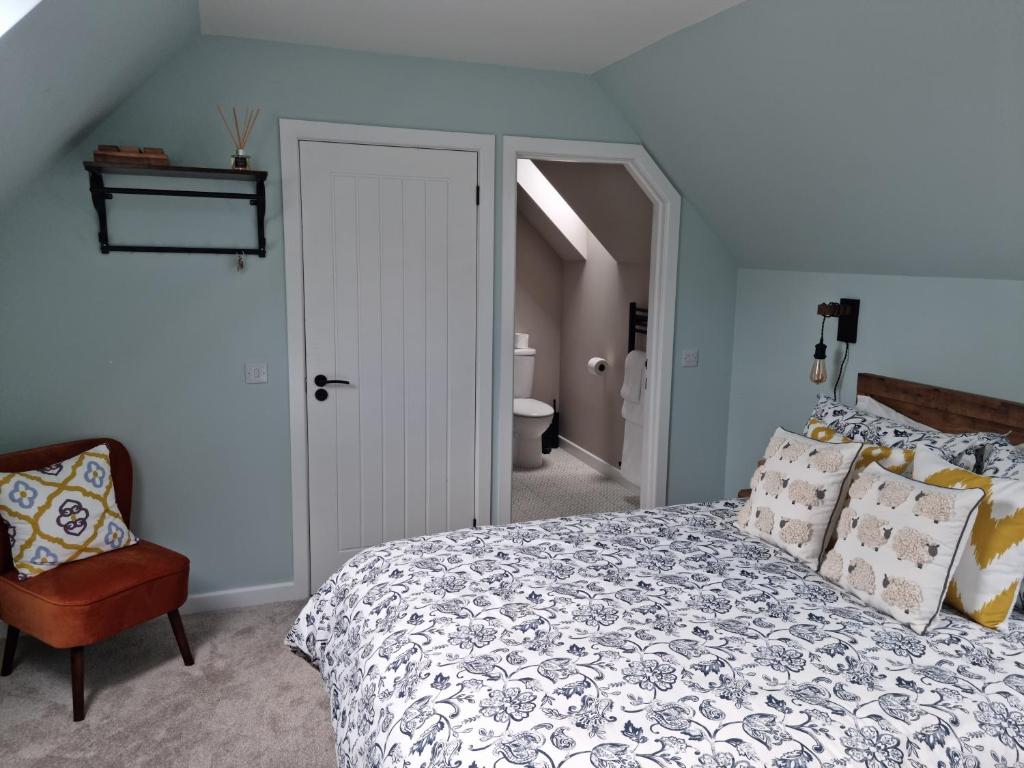 1 dormitorio con 1 cama y 1 silla en Barra's Loft, en Fort William