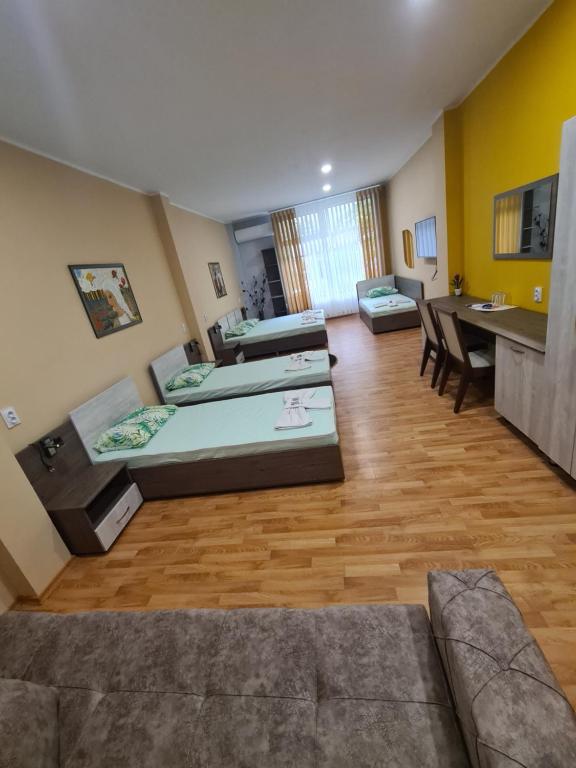 een grote kamer met 2 bedden en een tafel bij Семеен хотел Аристо in Dryanovo