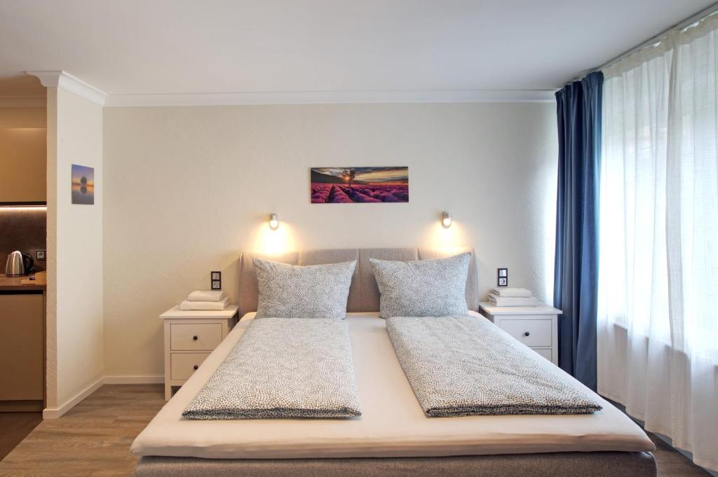 a bedroom with a large white bed with two lamps at S.F.C. Apartments in Trier