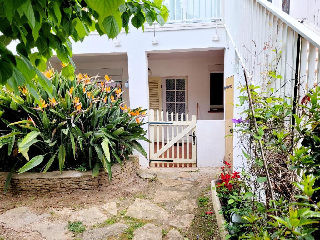 una entrada al jardín de una casa con flores en RDC de Villa de 35 m2 - 400 m Plage en Six-Fours-les-Plages