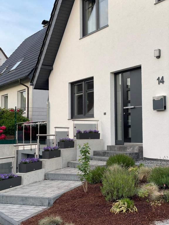 a white house with black windows and purple flowers at OD Ferienwohnung in Bad Salzuflen