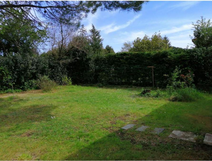 a yard with a fence and a field of grass at Emplacement de toile de tente dans jardin in Cugand