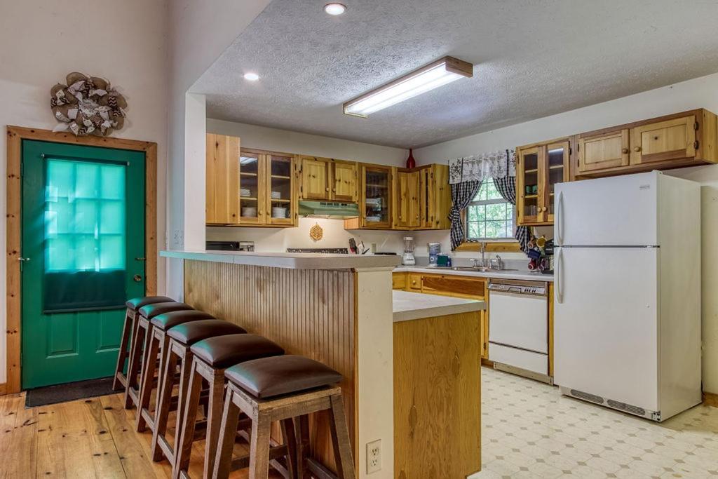 a kitchen with wooden cabinets and a white refrigerator at Laurel Cottage, 560 FREE tickets each paid day, Hot Tub, Pool Table! in Sevierville