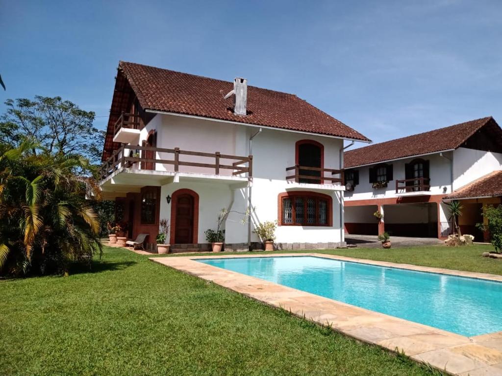 une villa avec une piscine en face d'une maison dans l'établissement Pousada Canto da Paz, à Petrópolis