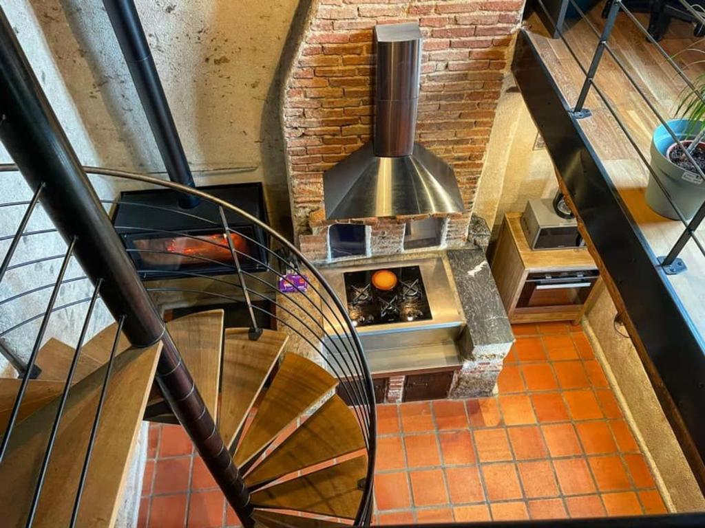 una escalera de caracol que conduce a una cocina con fogones en Gîte Le Menoux, 3 pièces, 5 personnes - FR-1-591-193, en Le Menoux