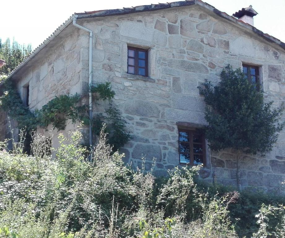 una vieja casa de piedra al lado de una colina en Luar no Xurés en Bubaces