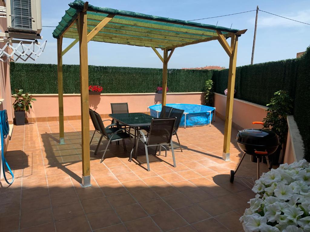 uma pérgola com uma mesa e cadeiras num pátio em Casa Mires em Deltebre