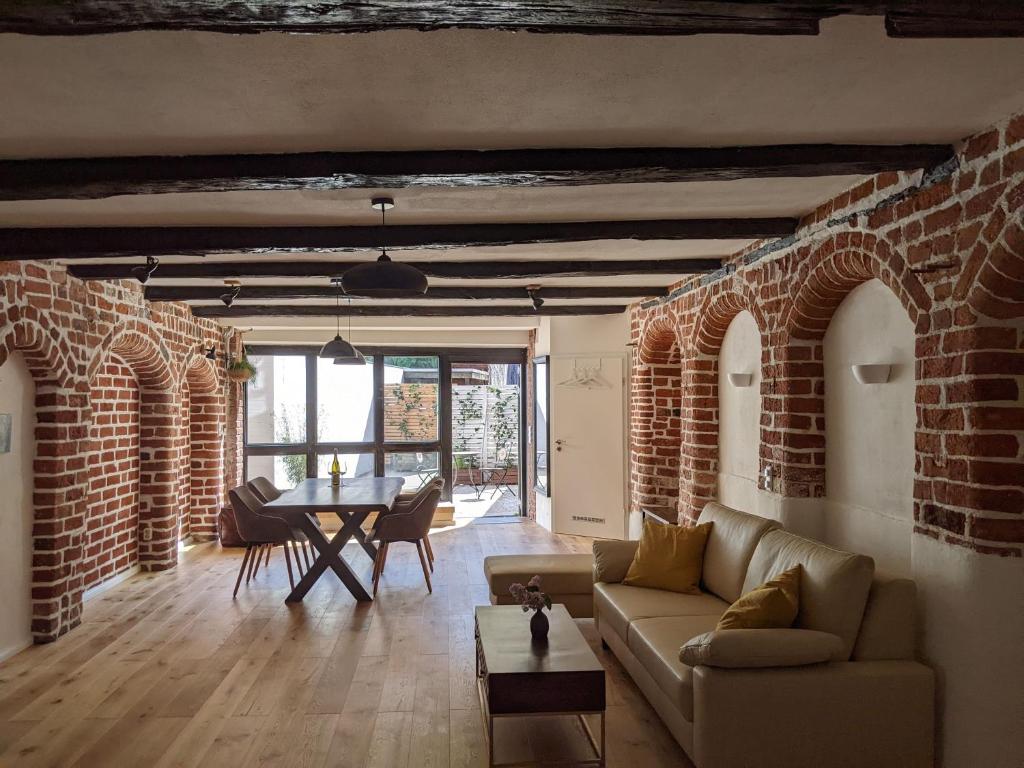 a living room with a couch and a table at BacksteinFlair - LüneMitte in Lüneburg