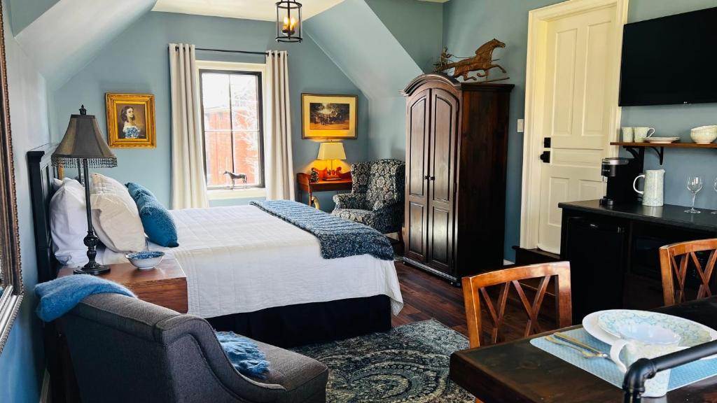 ein Schlafzimmer mit einem Bett, einem Stuhl und einem Tisch in der Unterkunft Stone's Throw Stratford in Stratford