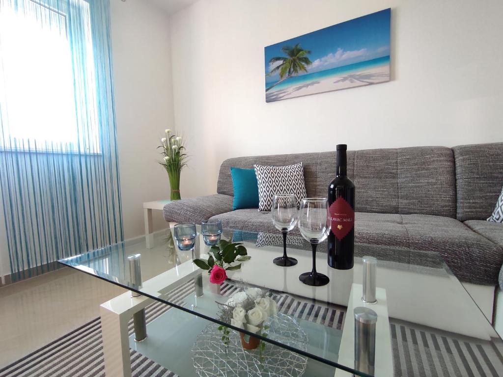 una sala de estar con una botella de vino y copas en una mesa en Apartment Žunabović, en Trogir