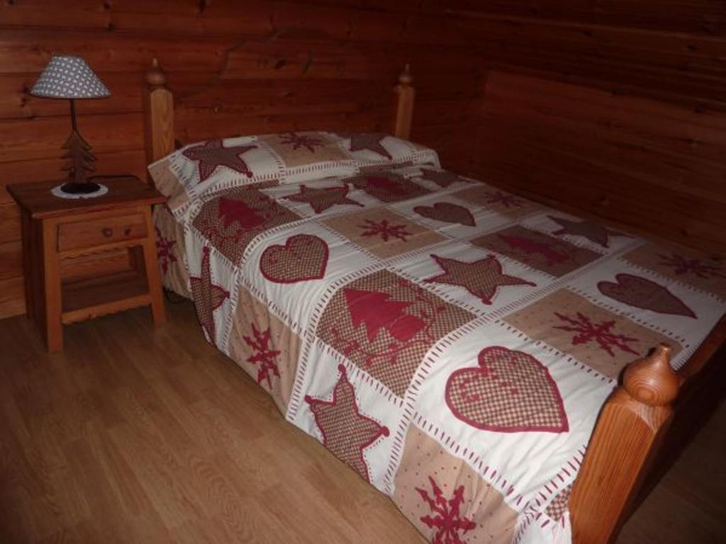 a bedroom with a bed with a quilt on it at Gîte Le Menil, 5 pièces, 5 personnes - FR-1-589-107 in Le Ménil