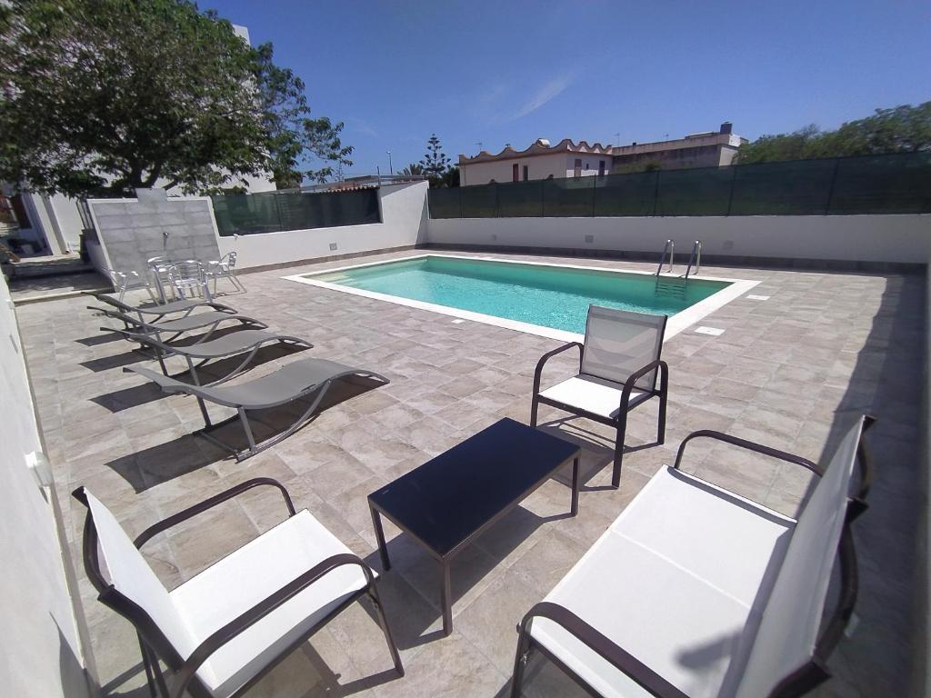 TriscinaにあるAPPARTAMENTO CON 3 CAMERE CON BAGNO INTERNO, CUCINA Sea & Sun 3の椅子、スイミングプール