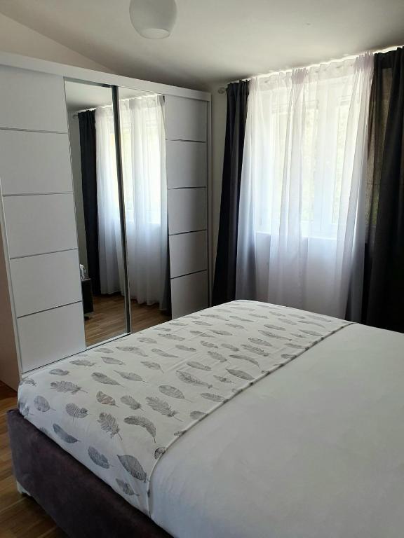 a bedroom with a large bed and a large mirror at Apartment Macic Dub II in Kotor