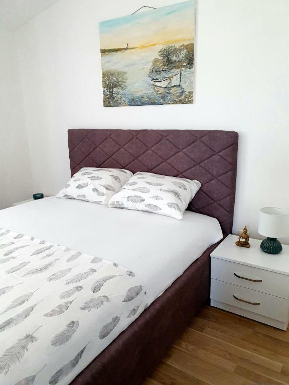 a bed with a purple headboard in a bedroom at Apartment Macic Dub II in Kotor