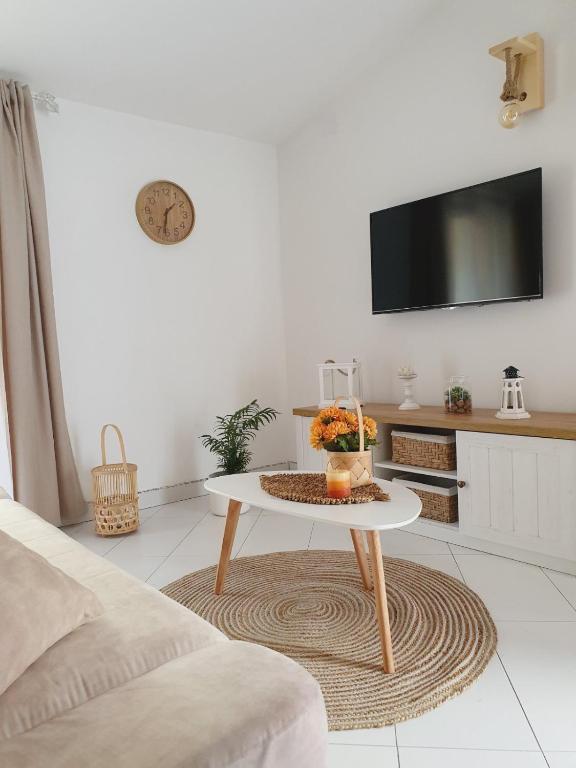 a white living room with a table and a tv at Apartment Macic Dub II in Kotor
