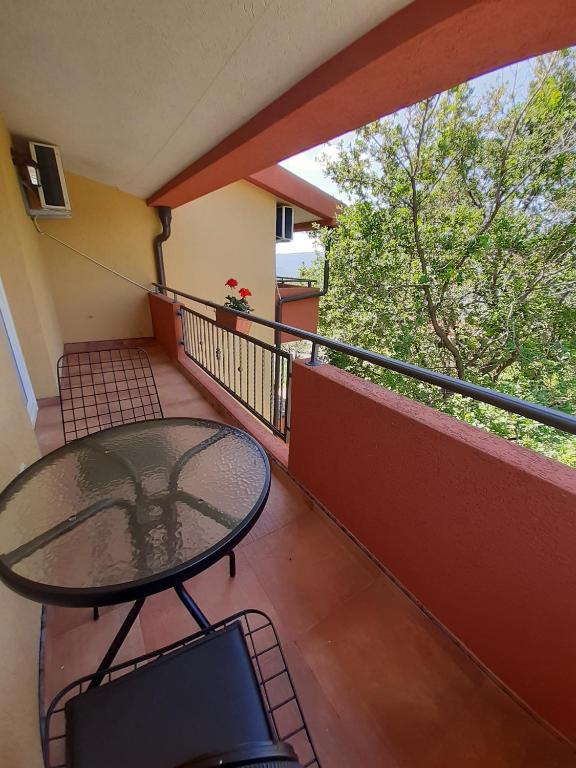 a balcony with a glass table on a balcony at Apartment Macic Dub II in Kotor