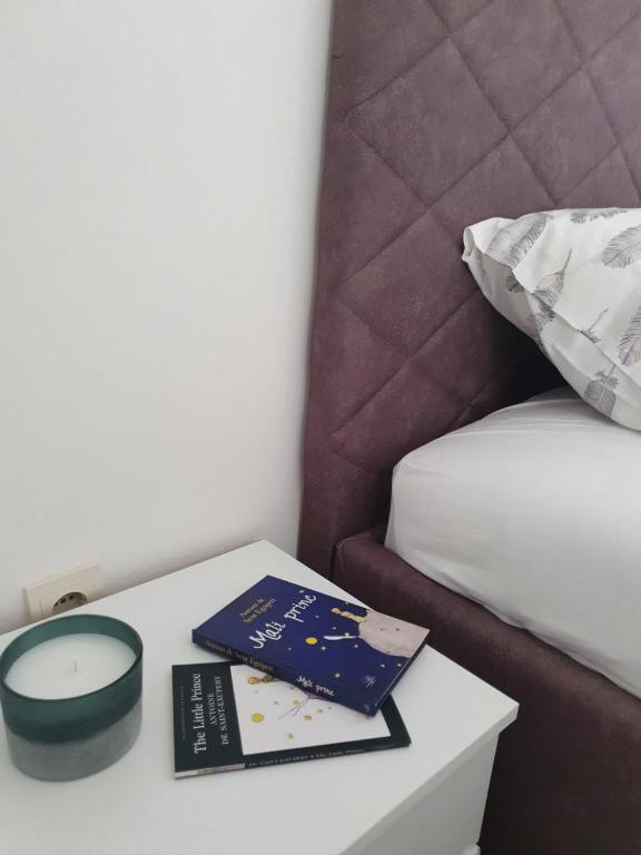 a table with two books on it next to a bed at Apartment Macic Dub II in Kotor