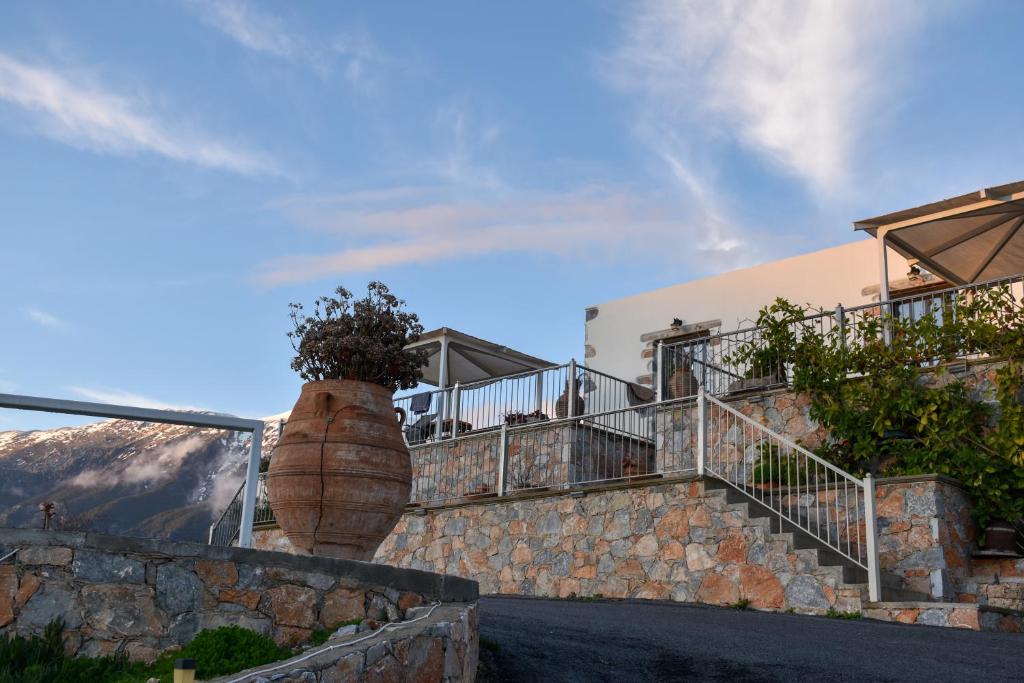 a building with stairs and a large vase with a plant in it at Madares Apartments Anopolis in Anopoli Sfakion