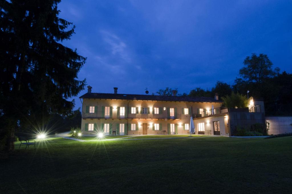 une grande maison avec des lumières sur un champ la nuit dans l'établissement Sangrato 1883, à Monteu Roero