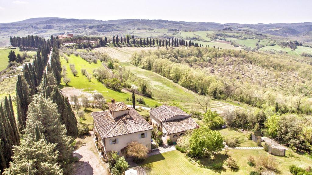 z góry widok na dom na wzgórzu z drzewami w obiekcie Appartamenti Villa La Fonte w mieście San Gimignano