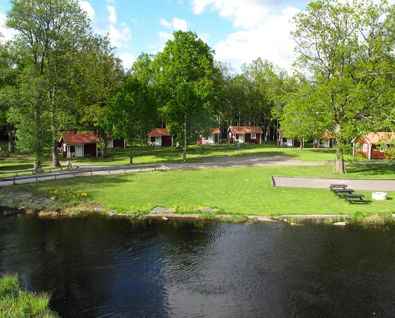 a park with a lake and a house at Orrefors Stugby o Vandrarhem in Orrefors