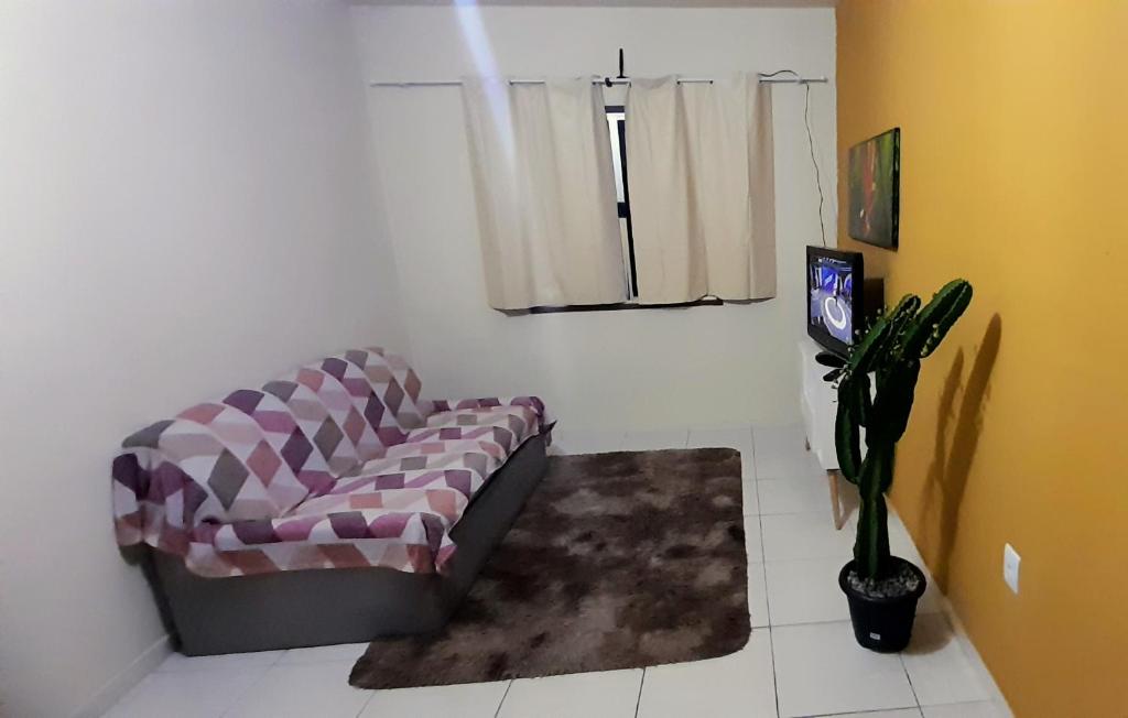 ein Wohnzimmer mit einem Sofa und einem Fenster in der Unterkunft Apto Aeroporto Macae in Macaé