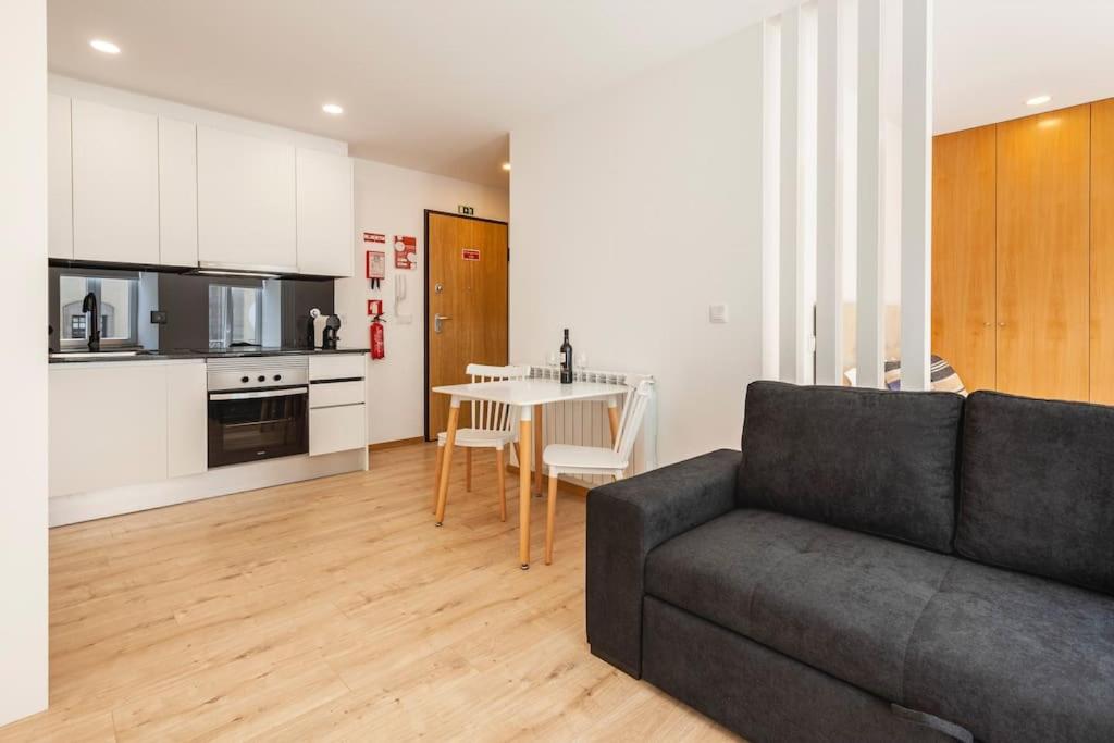 a living room with a couch and a table and a kitchen at Apartamentos Avenida Premium in Vila Real