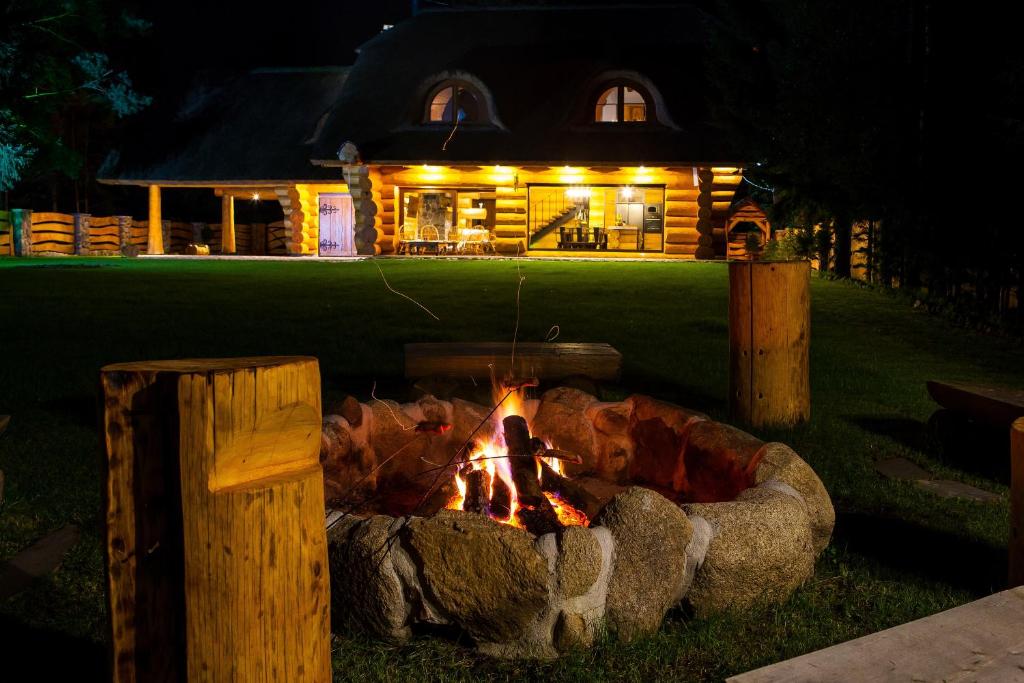 un focolare di notte davanti a una casa di SASKI ZAKĄTEK, WAKACJE W BAJKOWYM DOMKU!!! MAZURY, SAUNA, JEZiORO, POMOST, a Sasek Mały