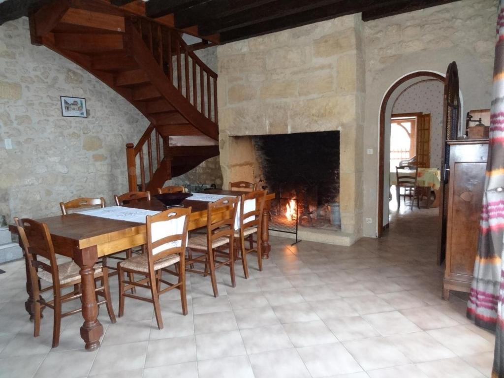 a dining room with a table and chairs and a fireplace at Gîte Domme, 5 pièces, 8 personnes - FR-1-616-23 in Domme