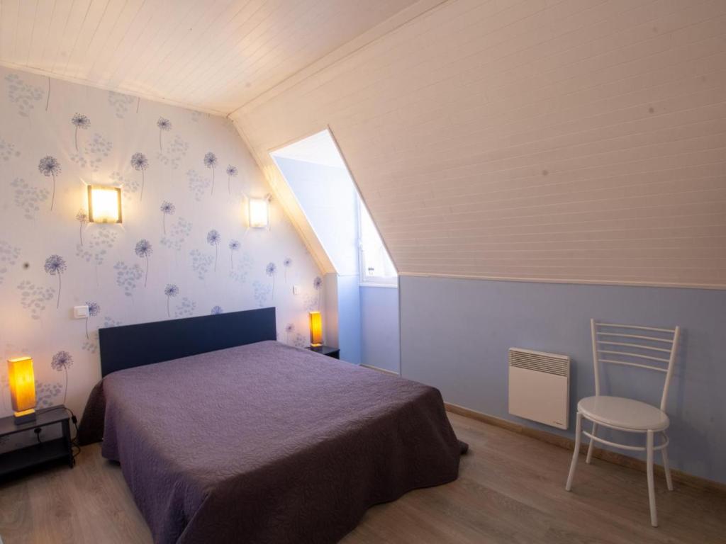 a bedroom with a bed and a window and a chair at Gîte Domme, 5 pièces, 8 personnes - FR-1-616-23 in Domme