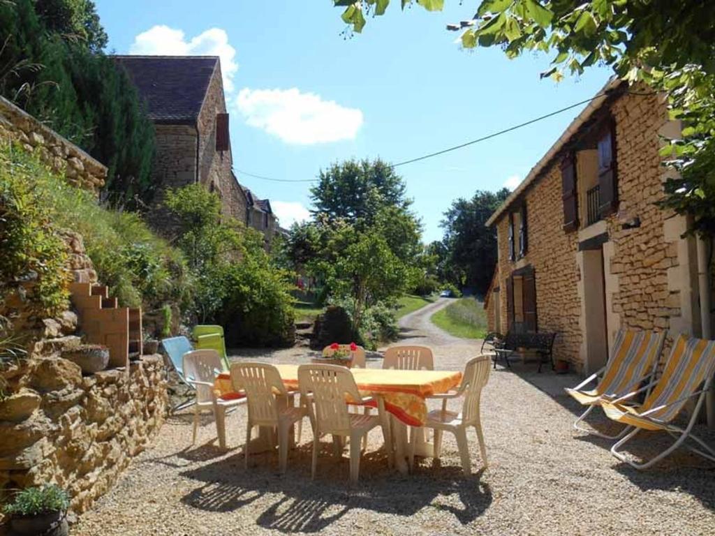 une table, des chaises, une table et des chaises dans l'établissement Charmante maison indépendante avec jardin, proche de Sarlat, Dordogne, idéale pour 6 personnes - FR-1-616-44, à Saint-Vincent-le-Paluel
