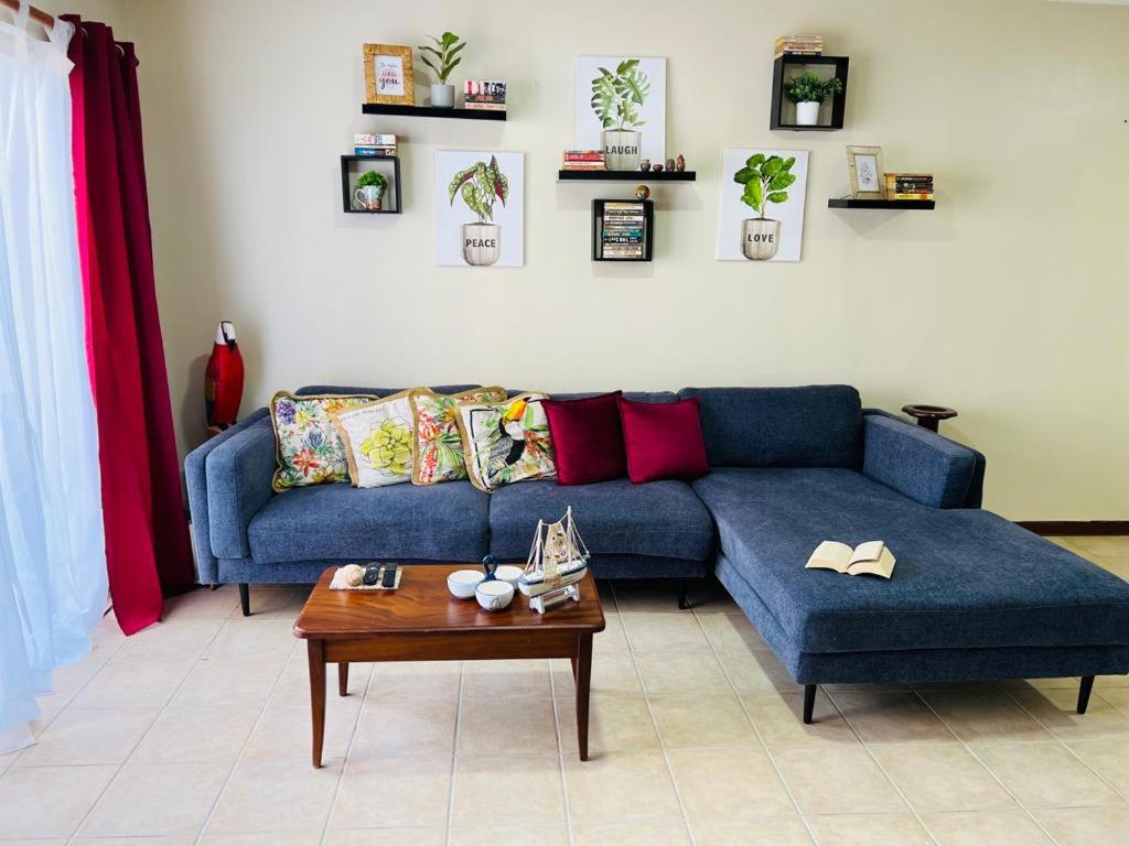 un soggiorno con divano blu e tavolo di Apartamento The Garden a Liberia